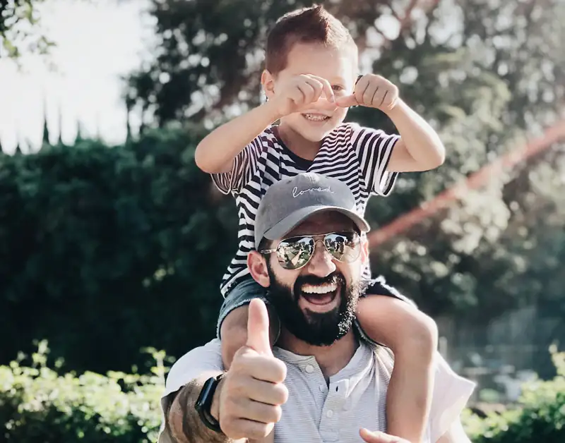 Padre con figlio sulle spalle